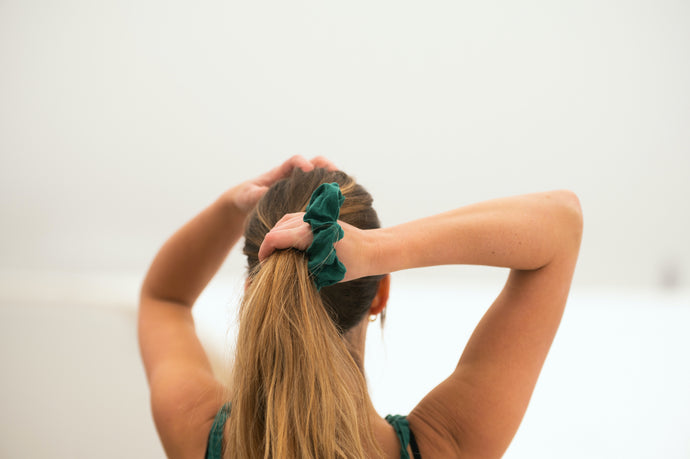 Tying up your hair with the Emerald Scrunchie